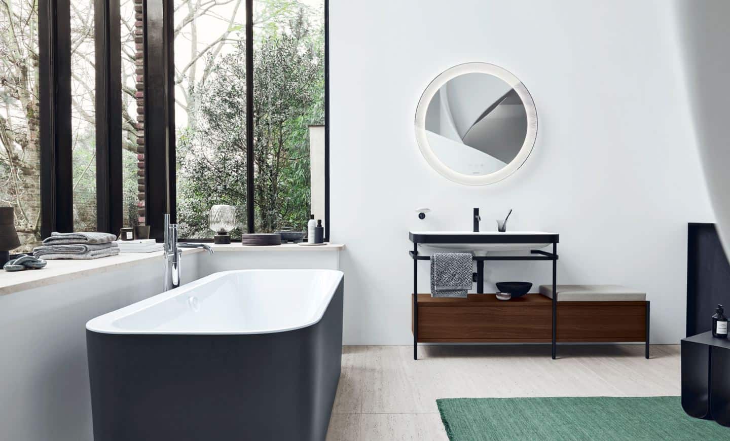 Duravit Happy D.2 Plus C-Shaped bathroom range. Free-standing bathtub with matt black exterior and sink console with a seat and extra storage.