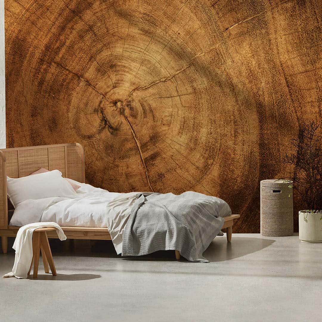 A bed in front of a wall mural depicting rings of wood from EverWall