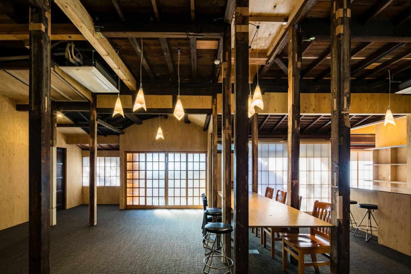 Japanese Style at Home Book Review - Exposed beams and	columns add colour and	texture to this large room, while low-hanging paper lanterns enhance the light from the large screened windows	