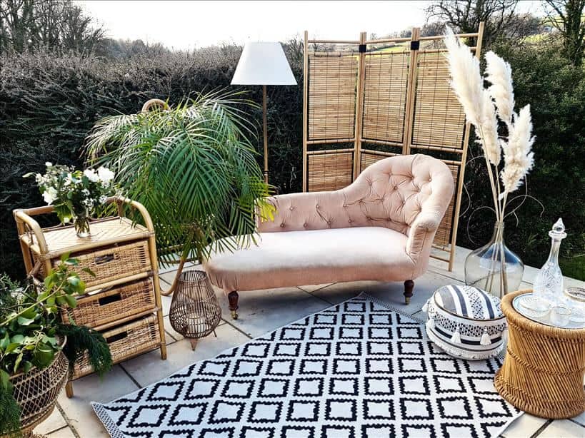 Entertain outdoors by setting up a chaise longue, rugs, pouffes, lamps, vases, lanterns and a wooden screen