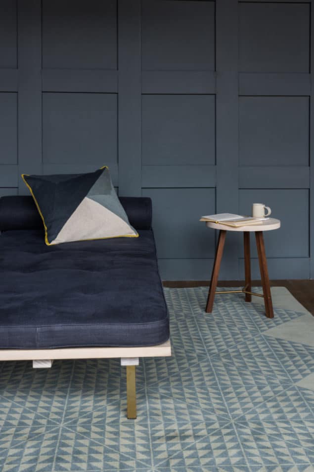 Grey room featuring a geometric rug and cushion by Niki Jones