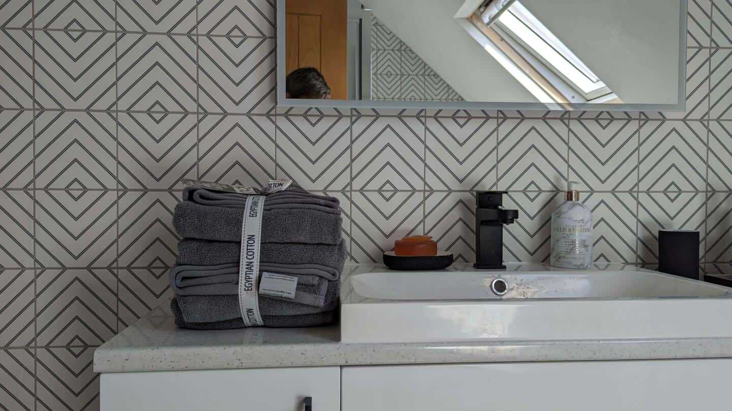 Grey Egyptian Cotton Bath Towel Bale next to a sink on a vanity unit in a bathroom