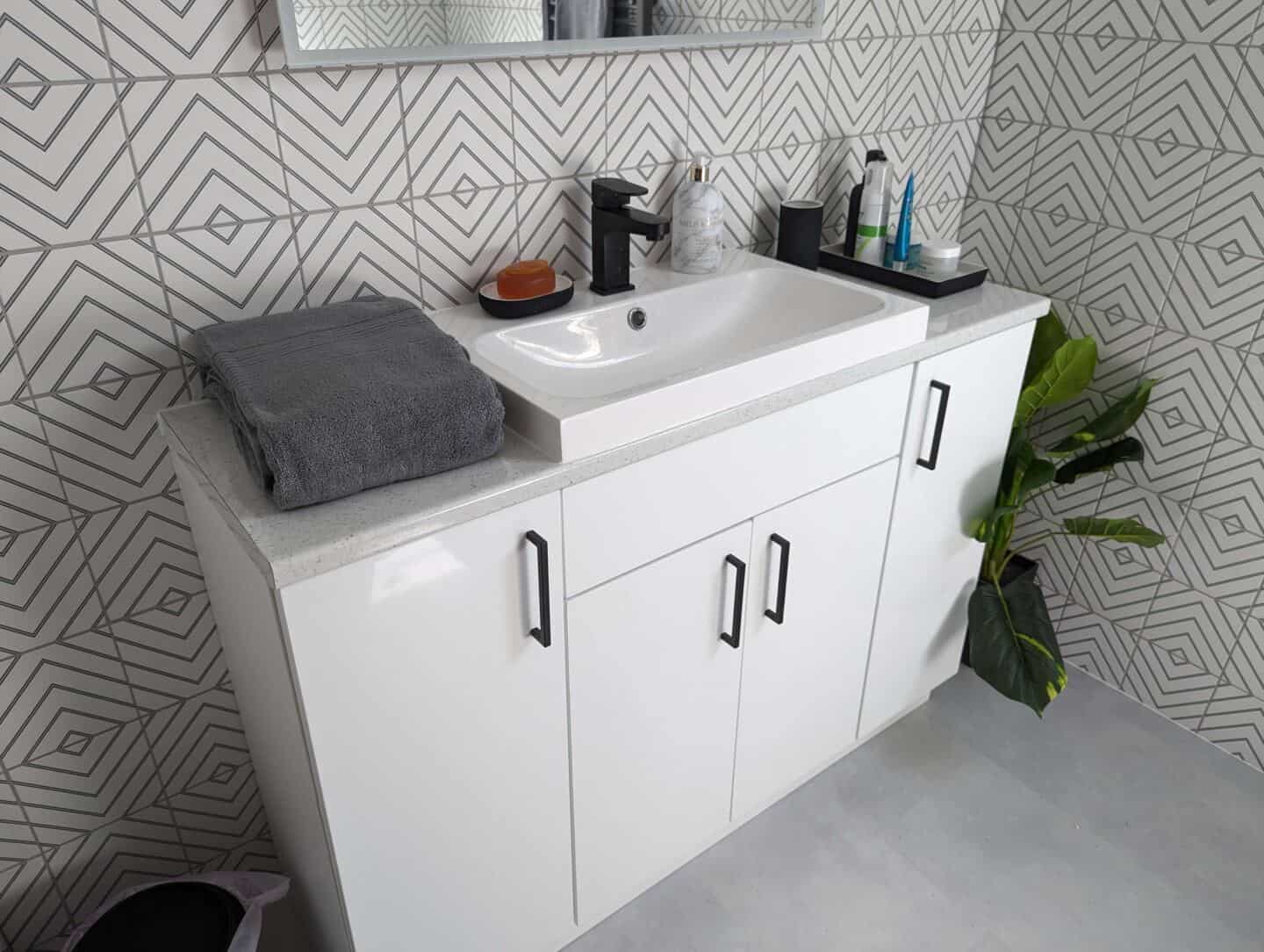 Grey Bath Towel next to a sink on a vanity unit in a bathroom