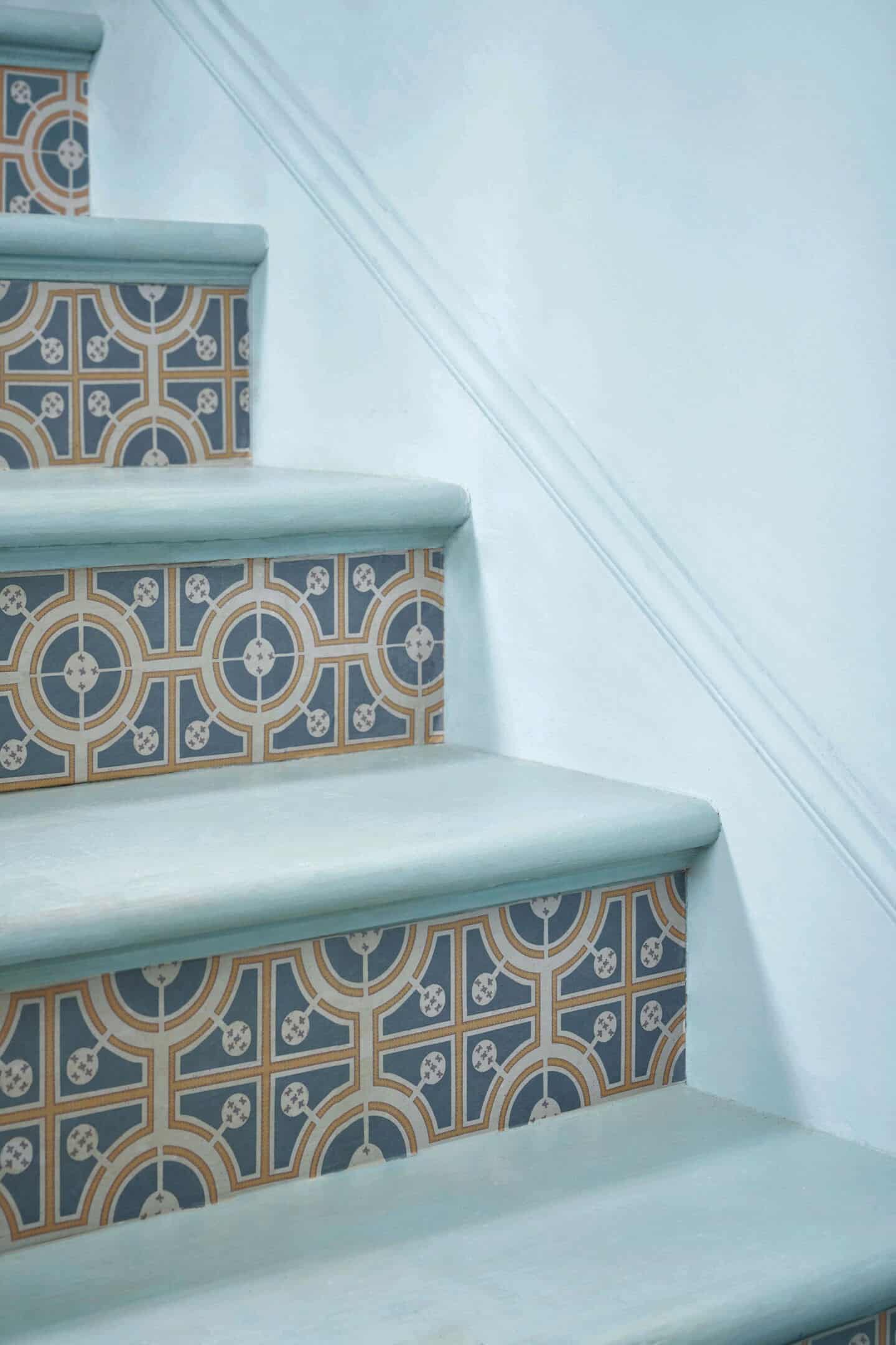 A close up of a staircase with decoupage paper glued onto the risers