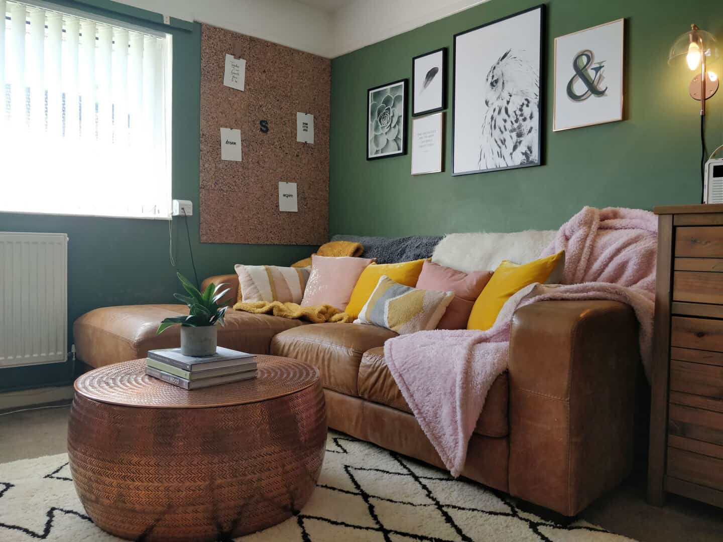 small home featuring living room with leather sofa, green walls and round copper coffee table