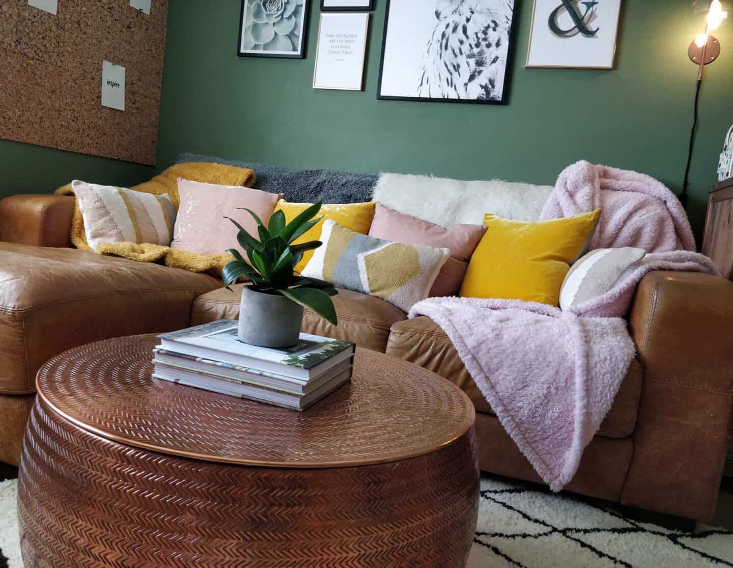 Autumn home updates with Habitat. A living room featuring a brown leather sofa, copper coffee table and pink and yellow velvet cushions.