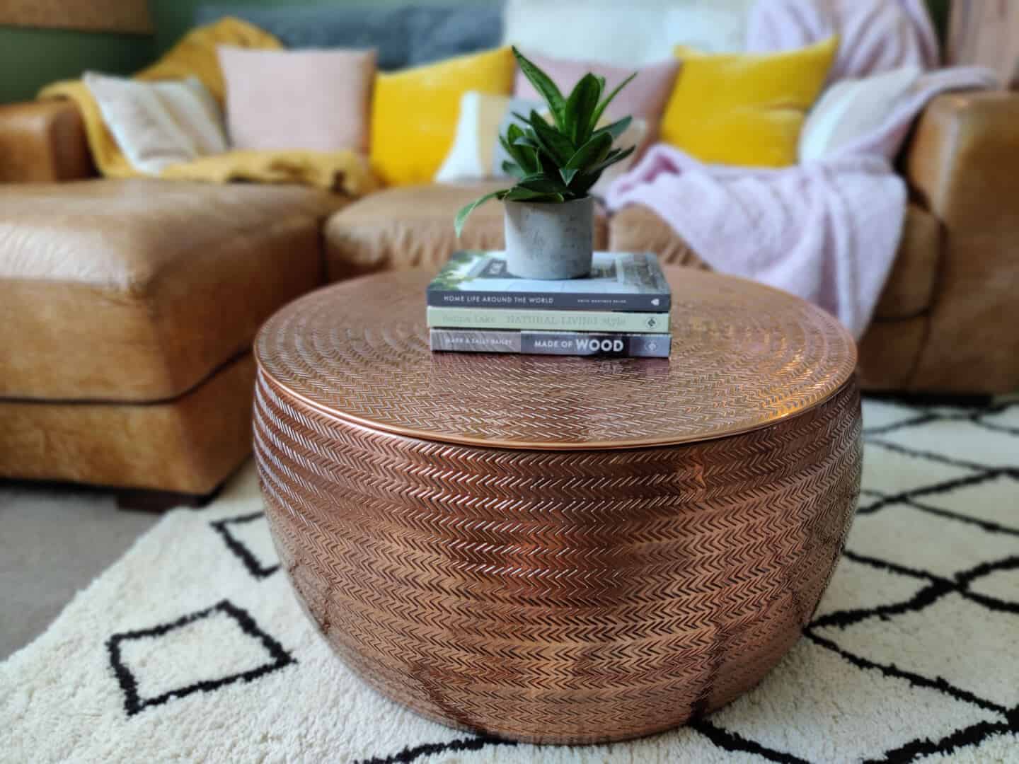 Autumn home updates with Habitat. A living room featuring a hand-etched copper coffee table on a berber rug.