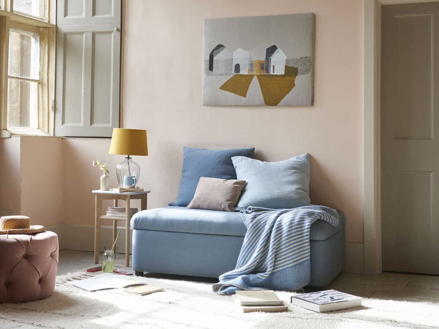 A guest bed folded up into an ottoman in a guest bedroom when not in use