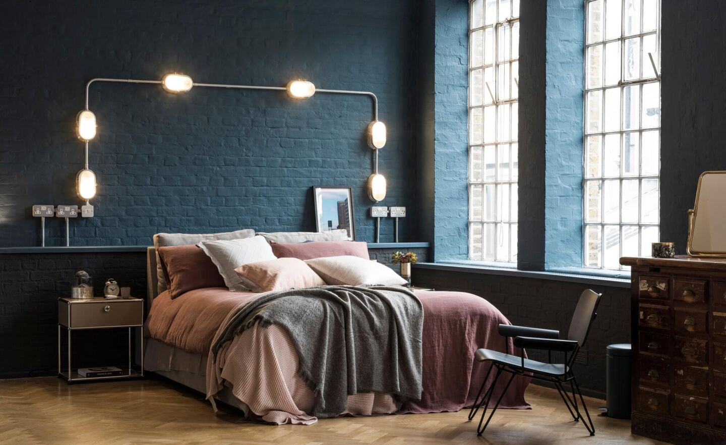 Loft style bedroom with parquet flooring and industrial-style windows