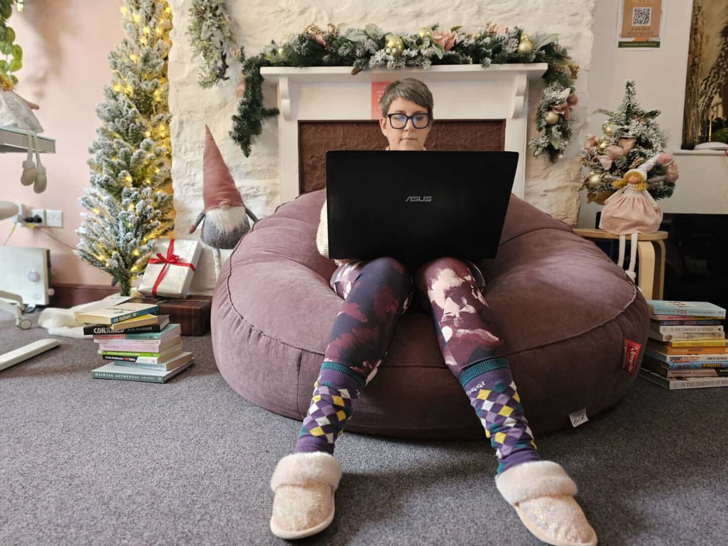 A woman in her forties sat on a huge bean bag working on her laptop