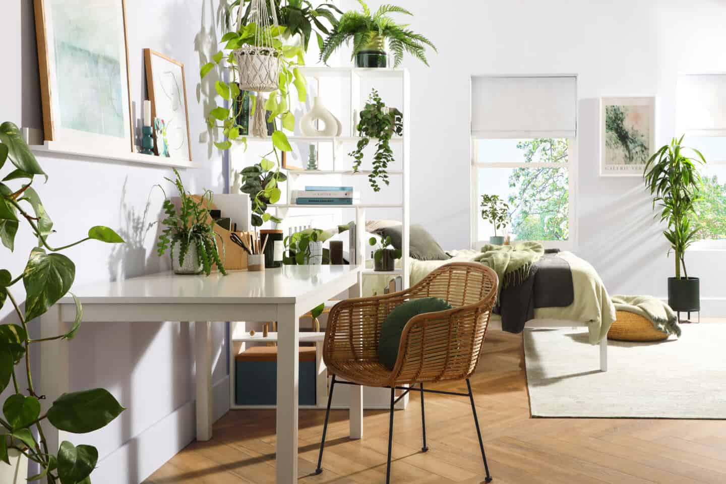 Plants in a bedroom that  has a small home office 