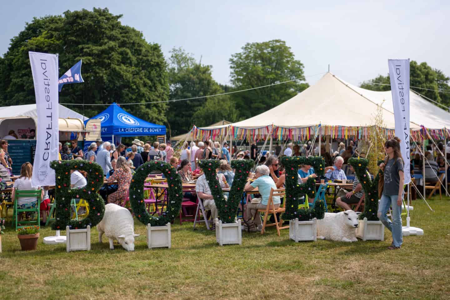 The Craft Festival at Bovey Tracy. The letters BOVEY made from plants in planters in front of the pop up tents at the festival