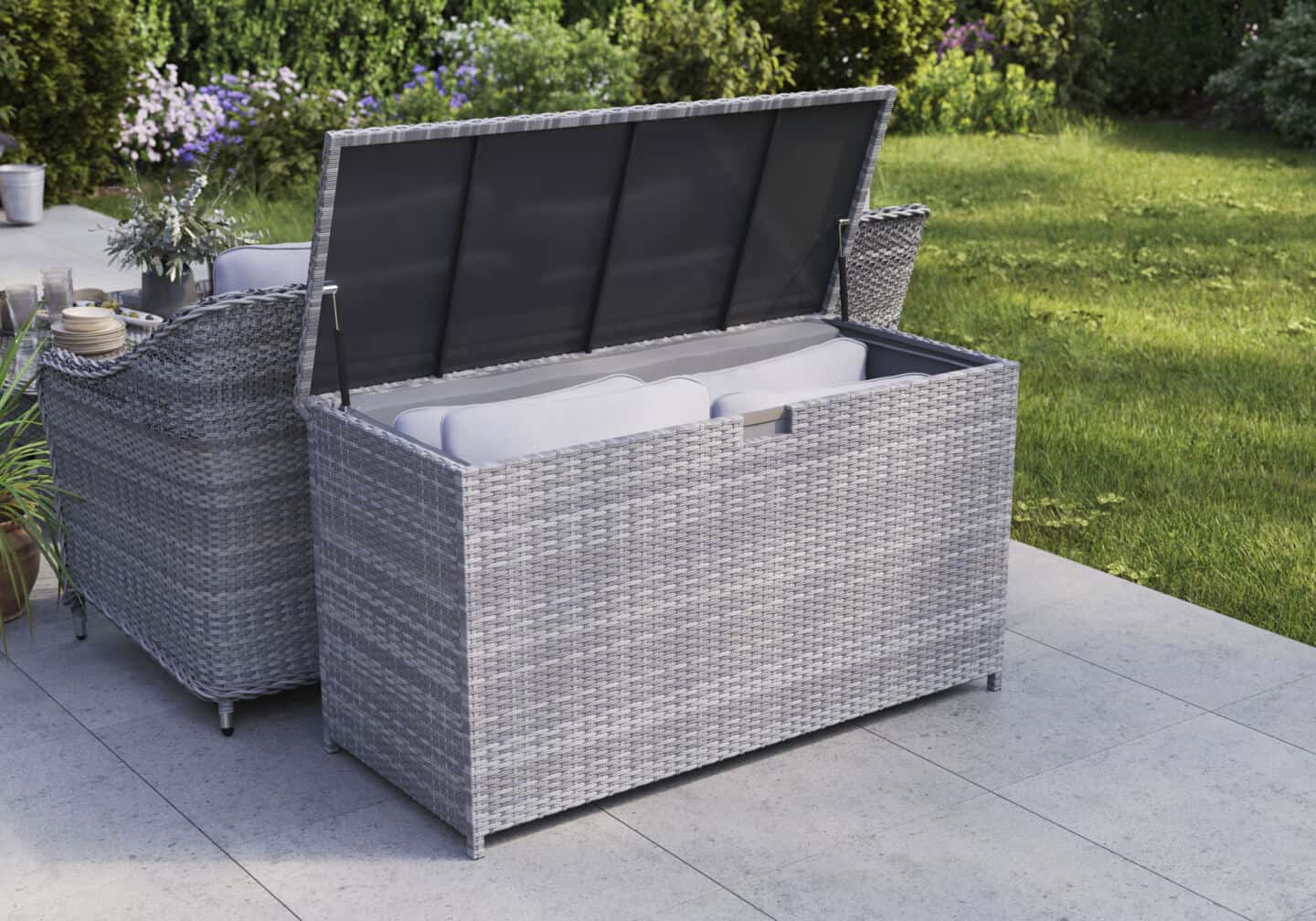 An open rattan effect garden storage box full of cushions