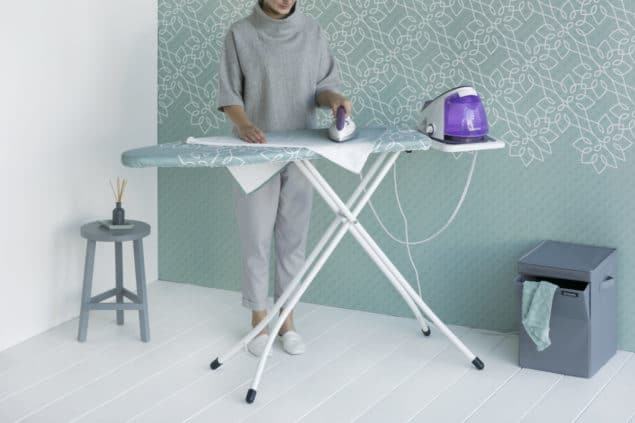 Lady ironing using a solid steam unit and a Brabantia Ironing Board