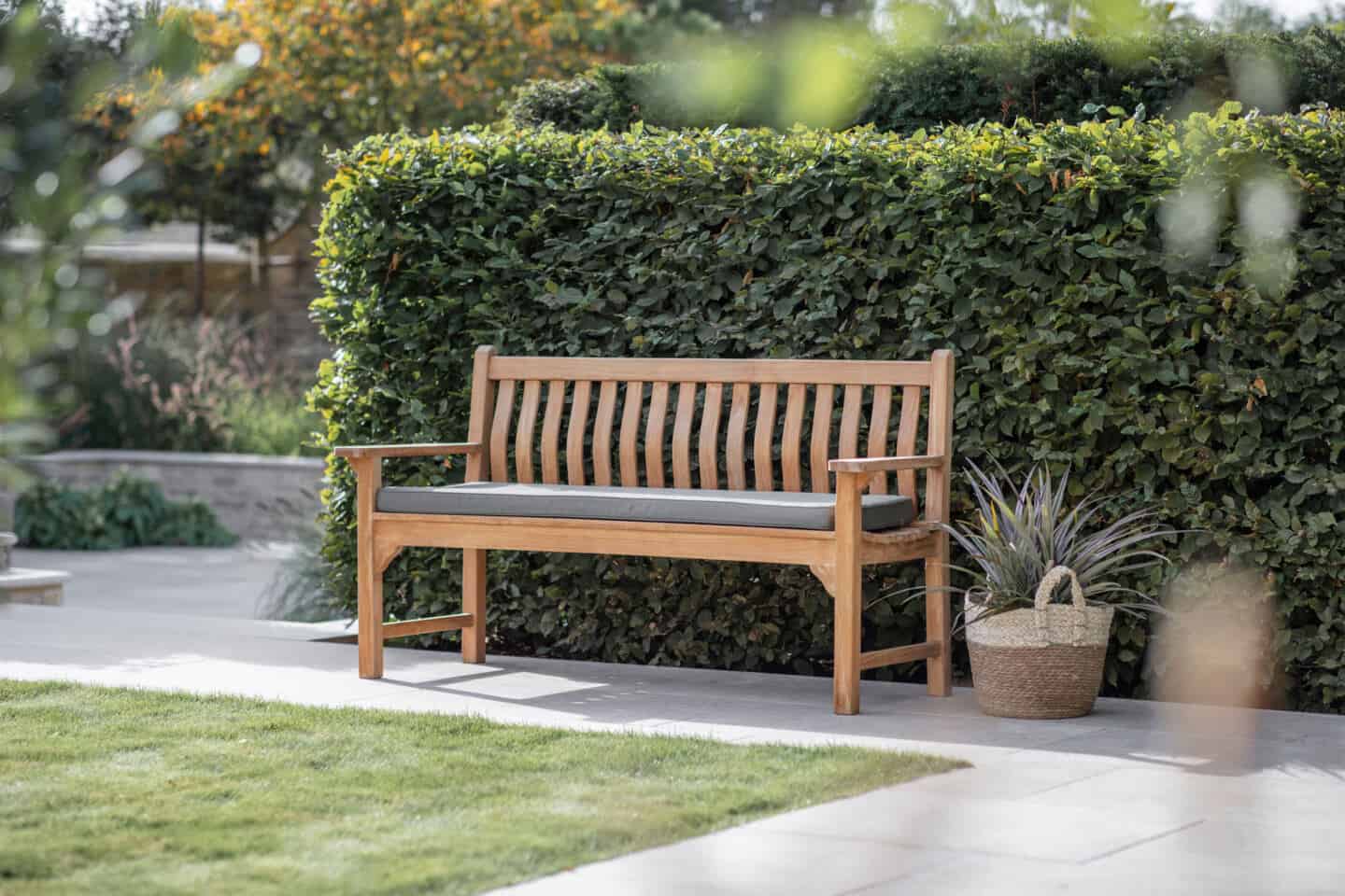 A bench against a hedge in a garden