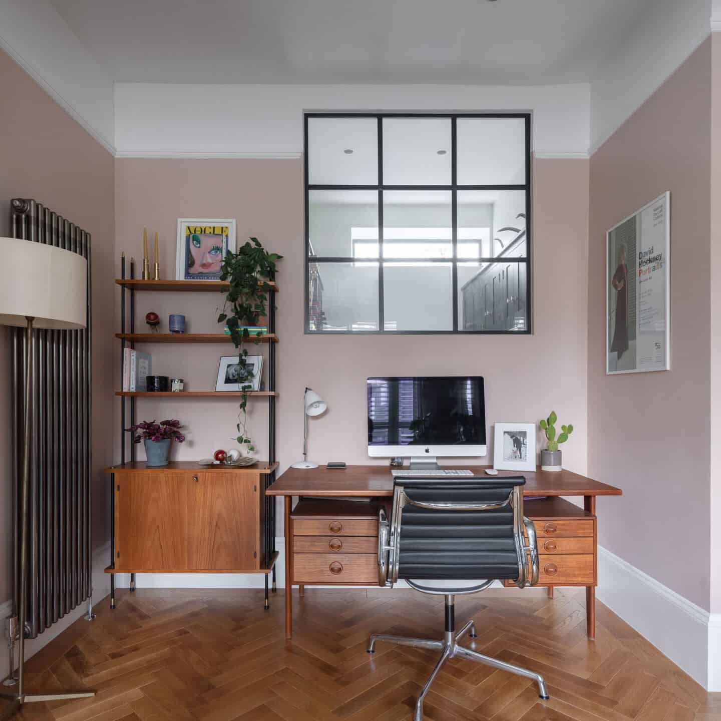 An internal window above a desk in a home office allows more natural light to circulate