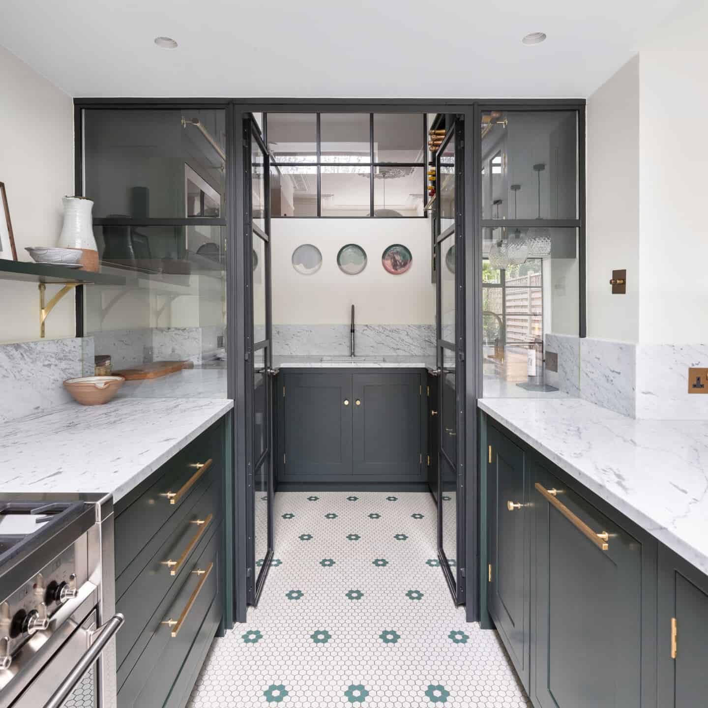 A kitchen partitioned off with glass doors. An internal window allows more natural light to circulate