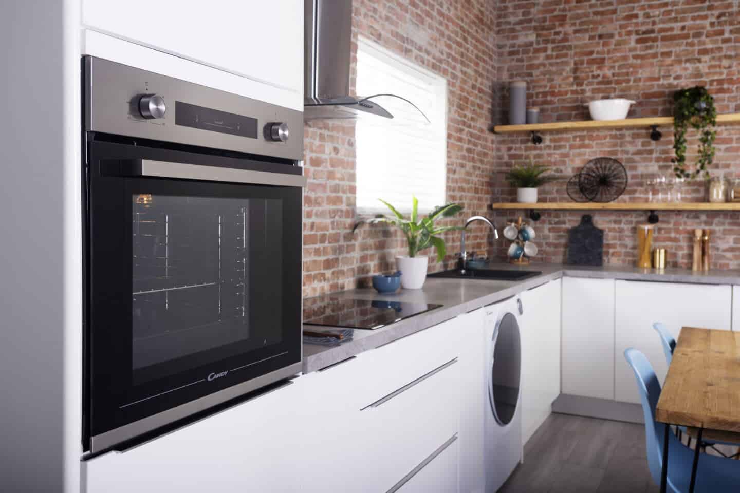 A white modern kitchen featuring a built-in oven