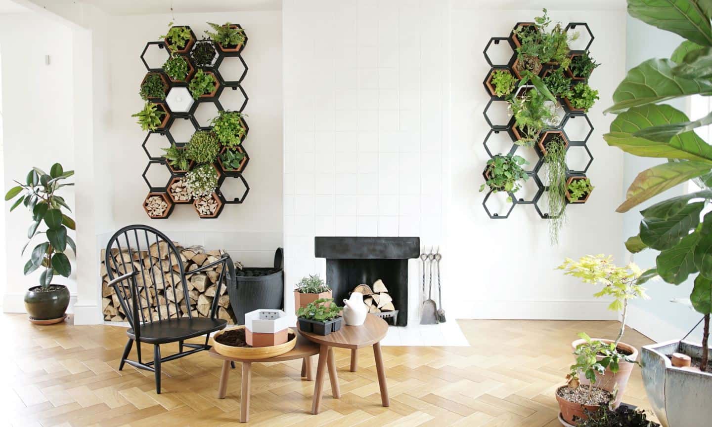 A living wall installed on white tiles walls next to a fireplace