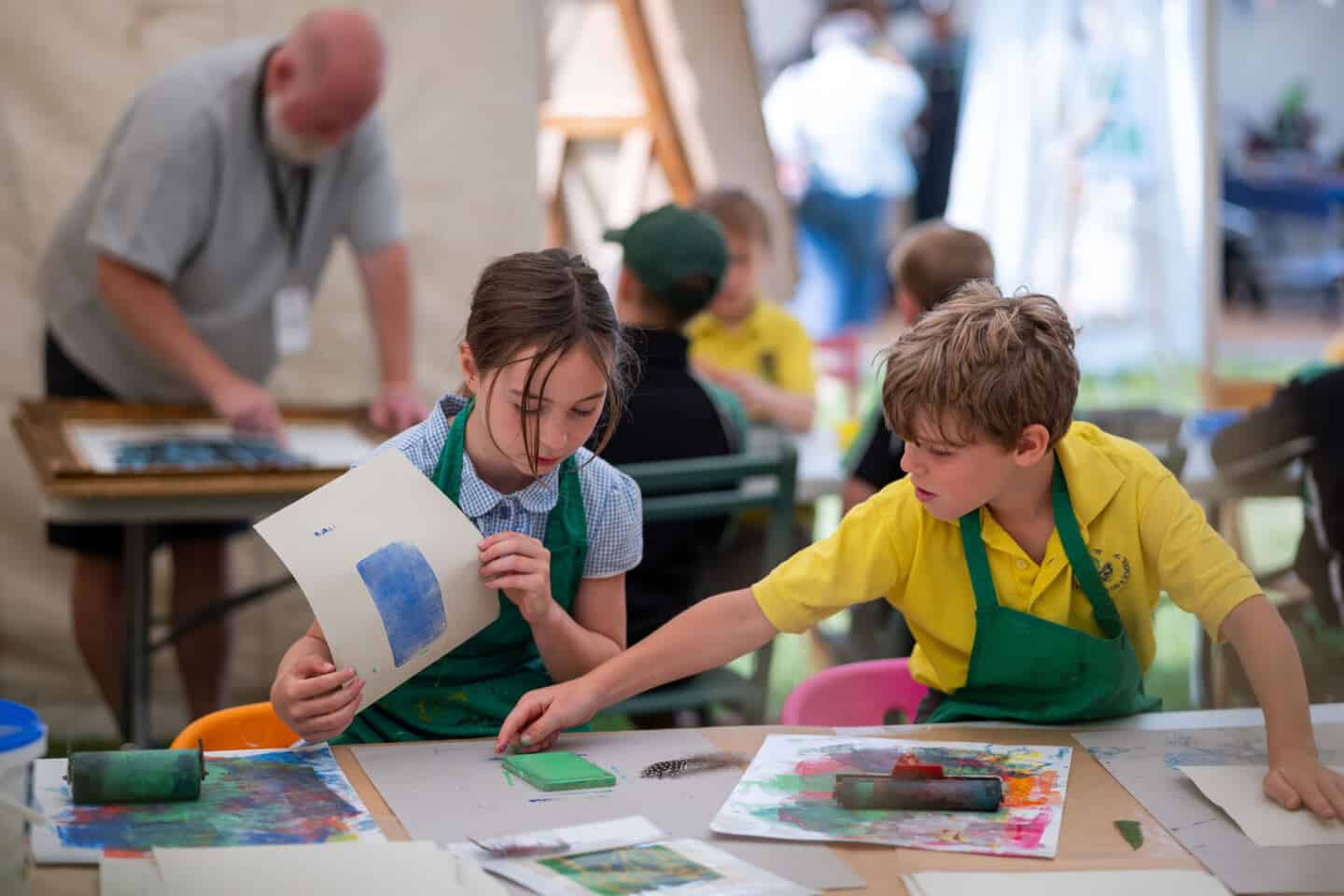 A young girl and a young boy take part in printing activities at the Craft Festival