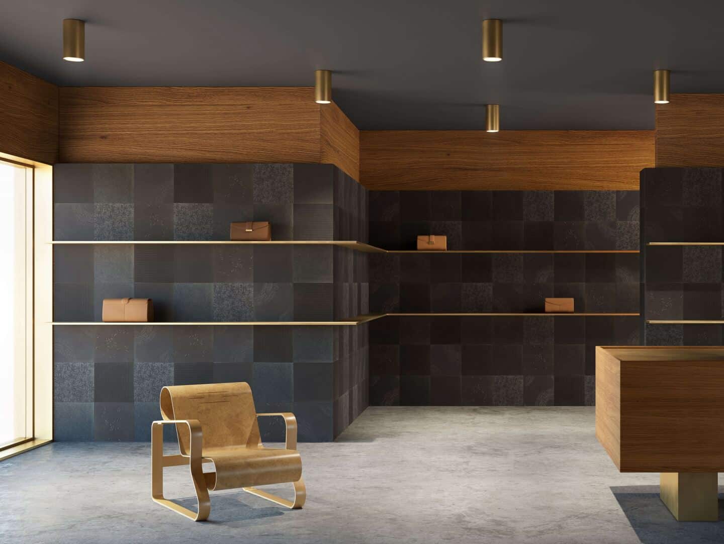 A showroom with square black wall tiles and gold shelves with handbags on them. A wooden chair is in the foreground 