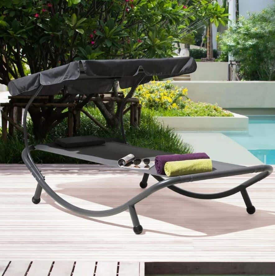 a garden sun lounger beside the pool with canopy to provide shade