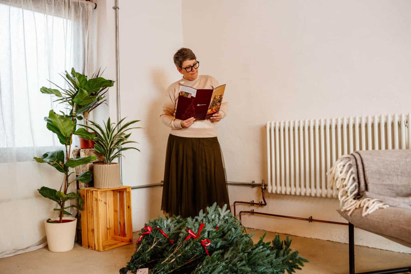 A woman in her forties reads the instructions for putting together a  realistic Christmas tree from Balsam Hill