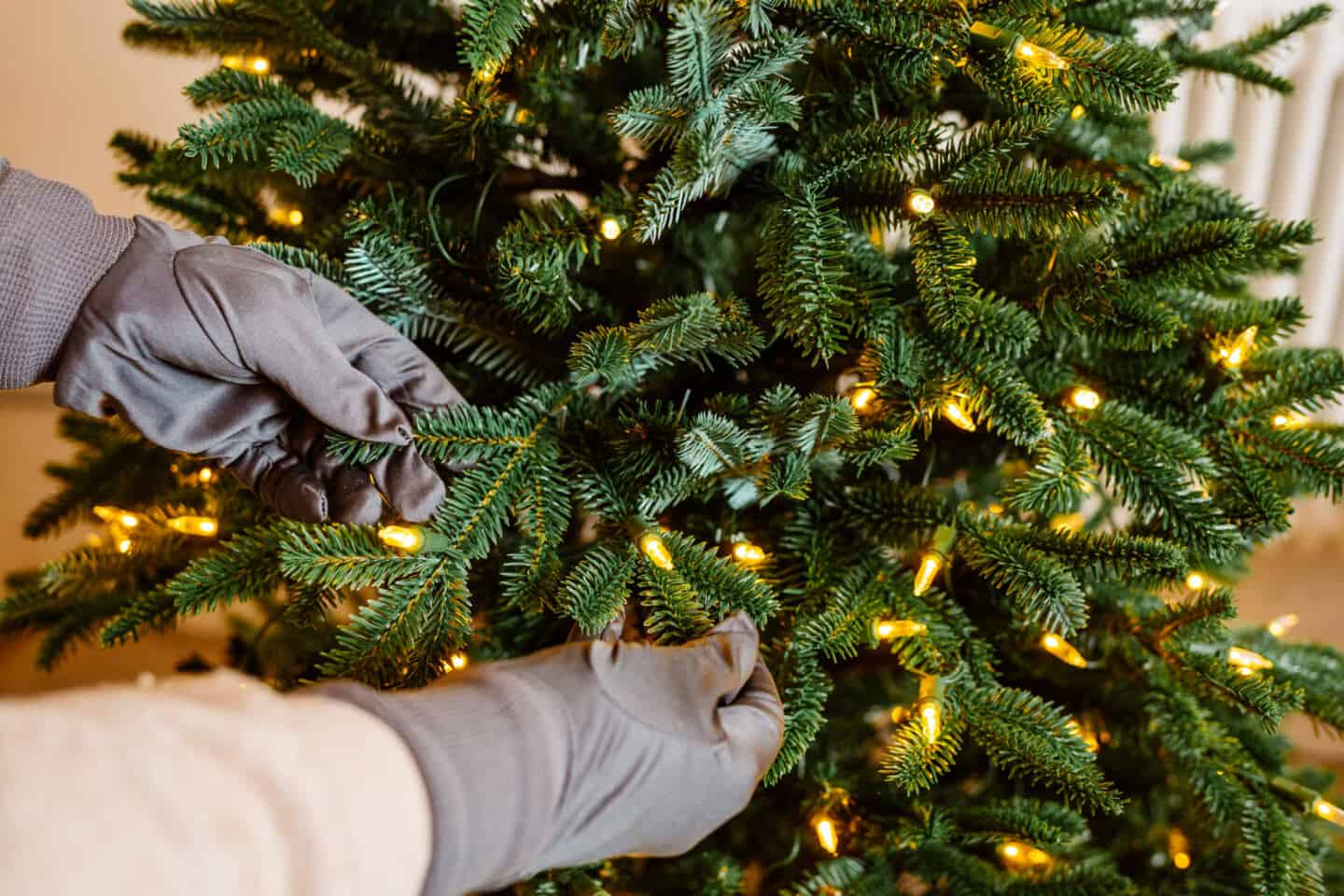 Gloved hands fluff and artificial Christmas tree from Balsam Hill