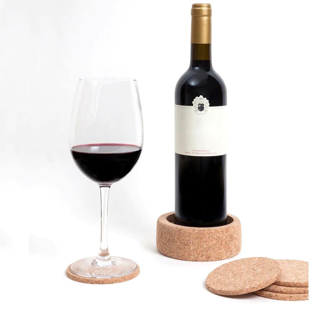 A glass of red wine on a cork coaster