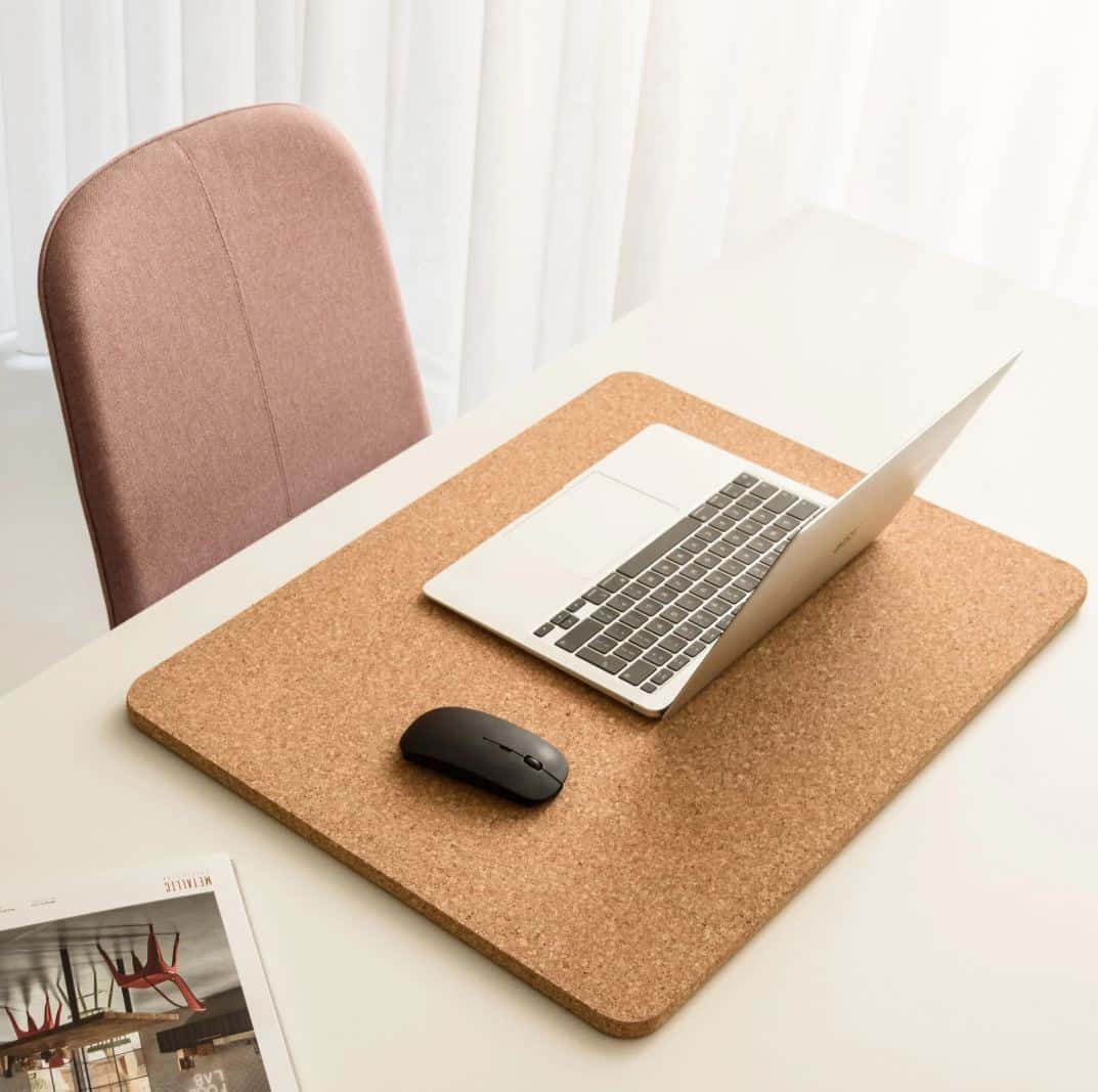 a cork desk mat with a laptop on it