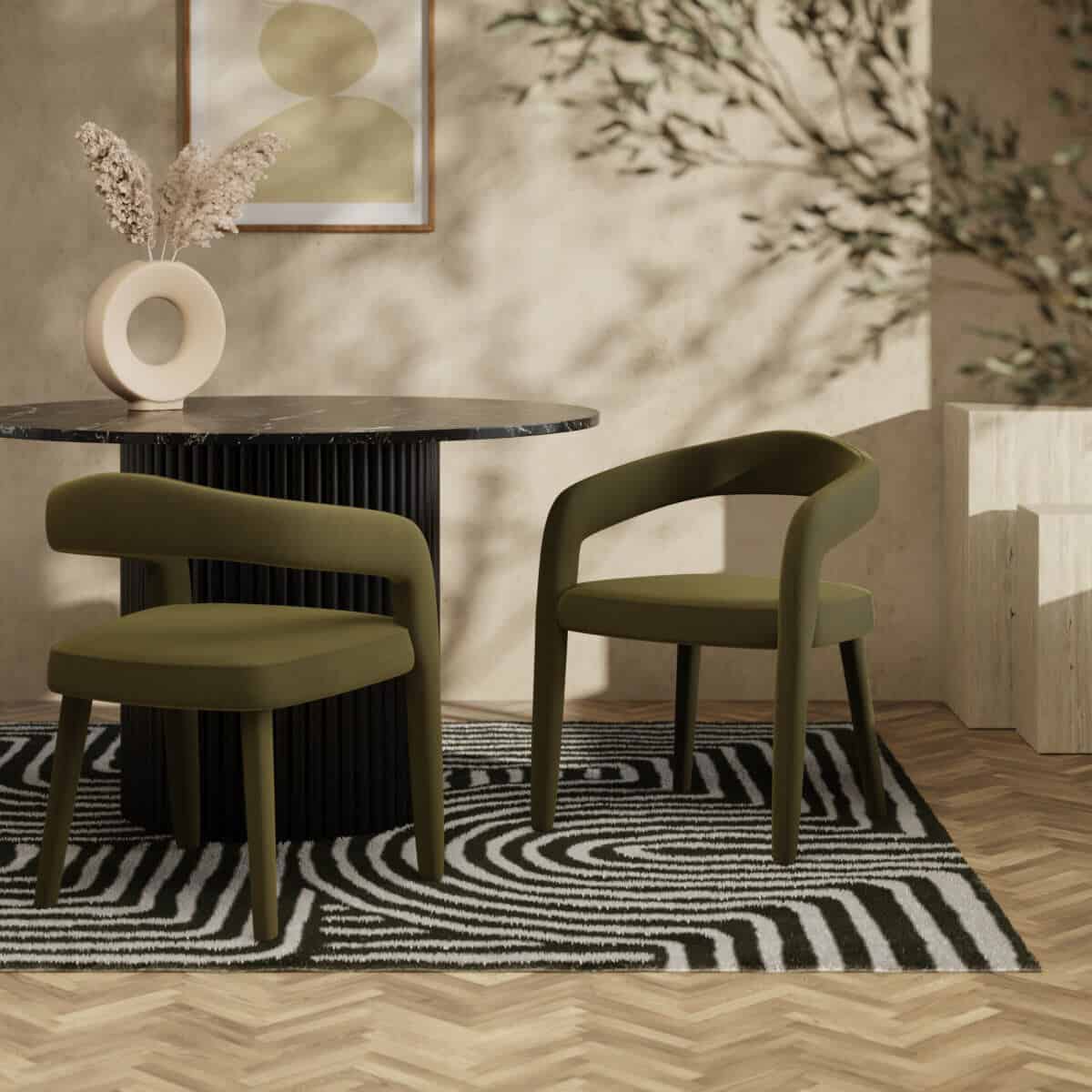 A minimalist marble topped dining table with ribbed column base. Two green velvet dining chairs on a geometric black and white rug