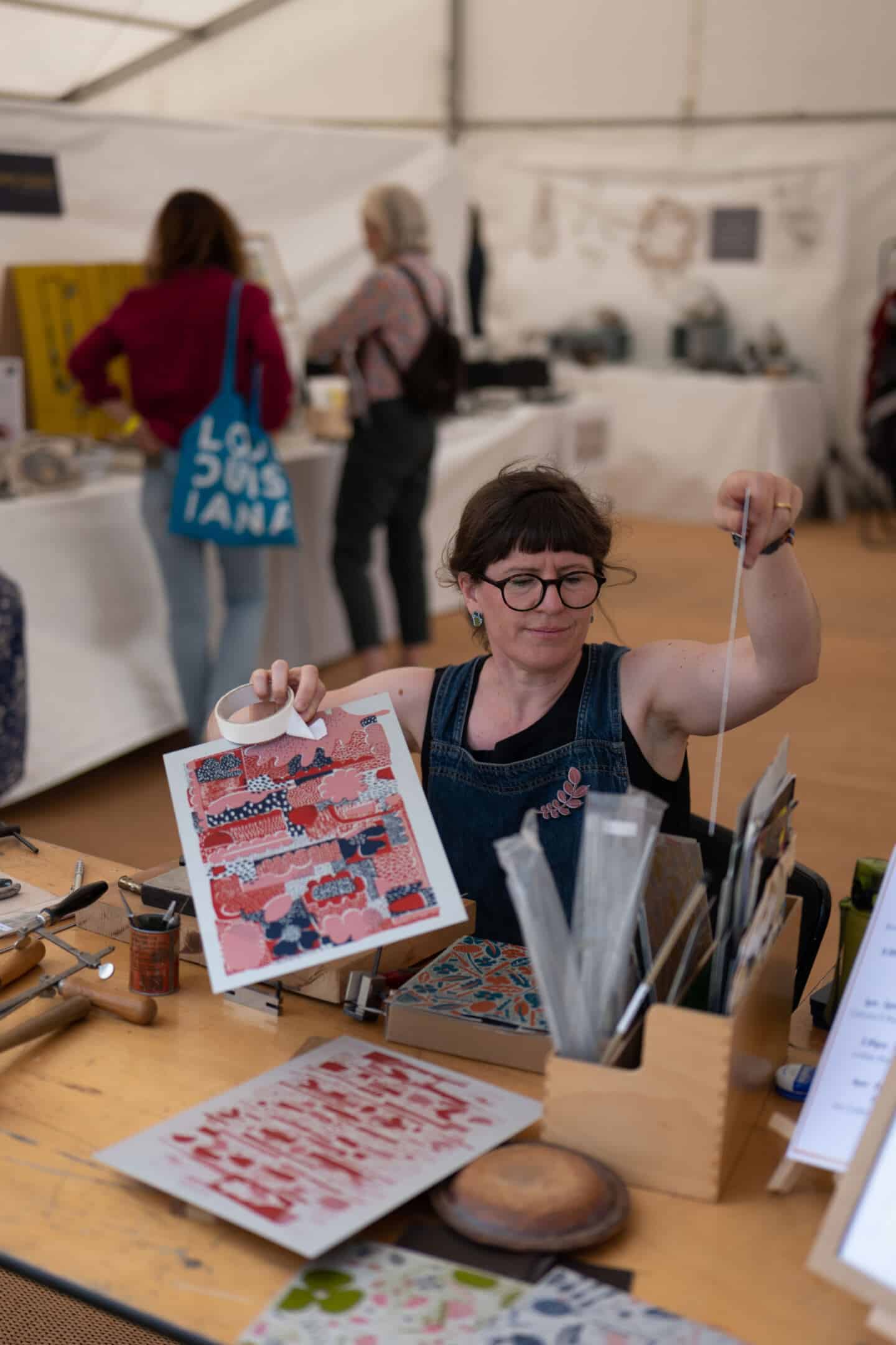 A woman from Design Nation mans a stand at The Craft Festival