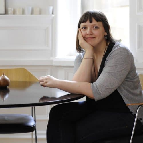 Interior Designer Niki Jones sat at a desk smiling