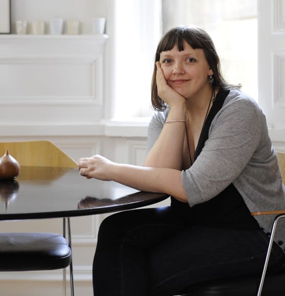 Interior Designer Niki Jones sat at a desk smiling