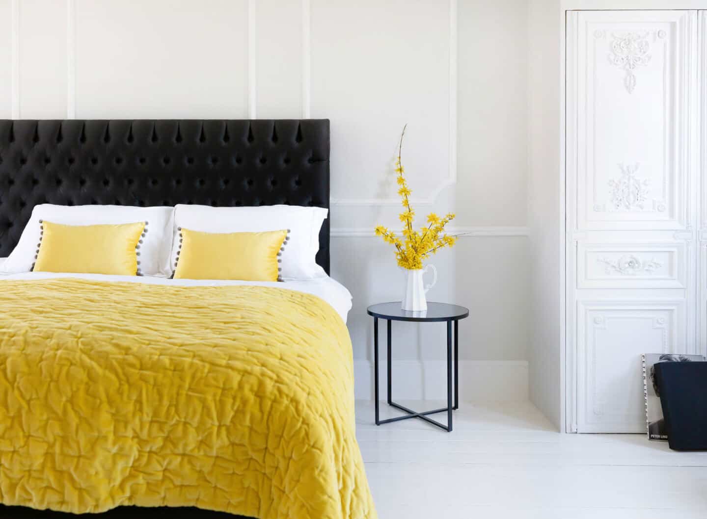 Pantone Colour of the Year 2021 - Illuminating. The colour psychology behind using yellow in interiors. A yellow bedspread and yellow cushions from The French Bedroom company on a bed in a white room