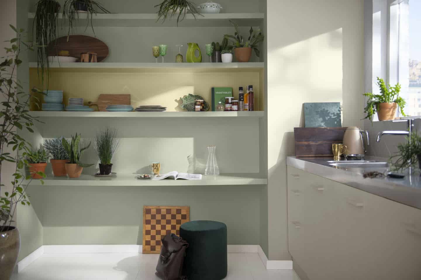 Open shelving in a kitchen painted in shades of green and yellow