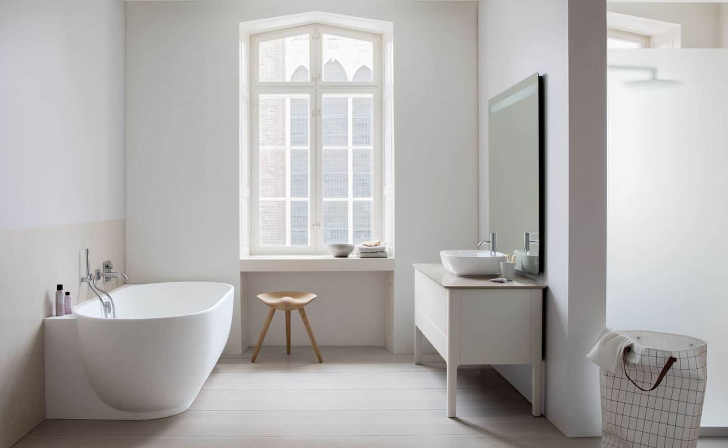 The Luv sanitary ware collection by luxury bathroom brand Duravit. A bathtub stand opposite a sink with a window behind.