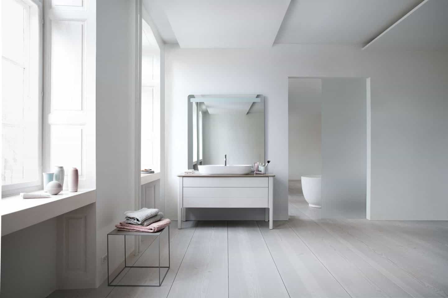 The Luv collection by luxury bathroom brand Duravit. Two large windows on the left and a basin on the adjacent wall.