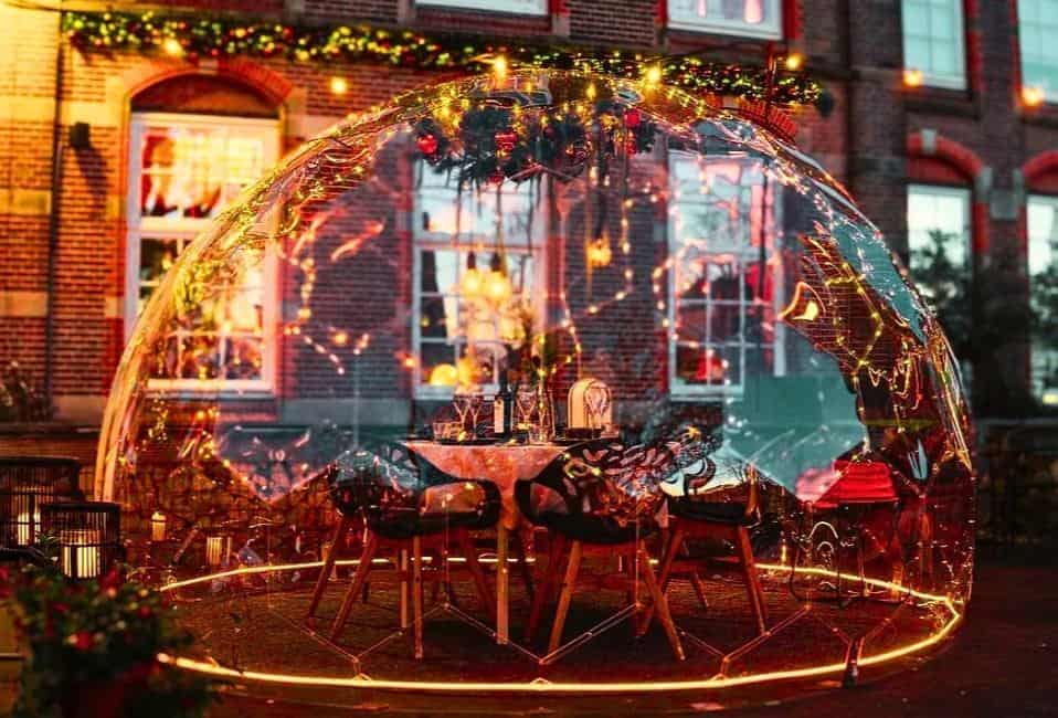 A table and dining chairs inside a garden dome with the table set for dinner