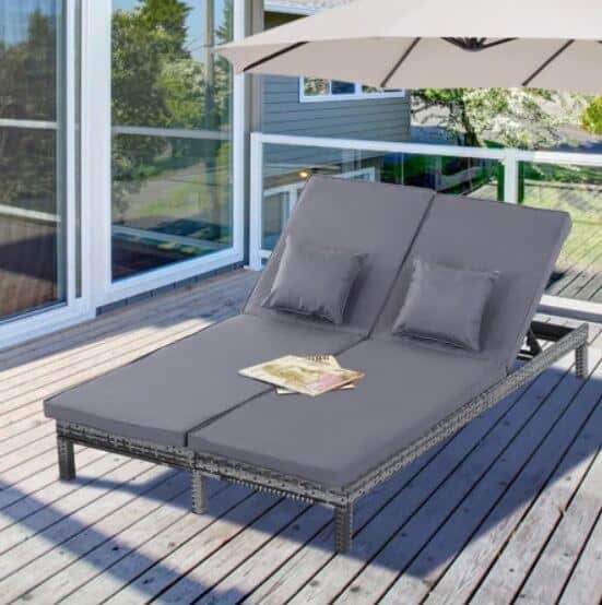 a double sun lounger on a deck under a large umbrella