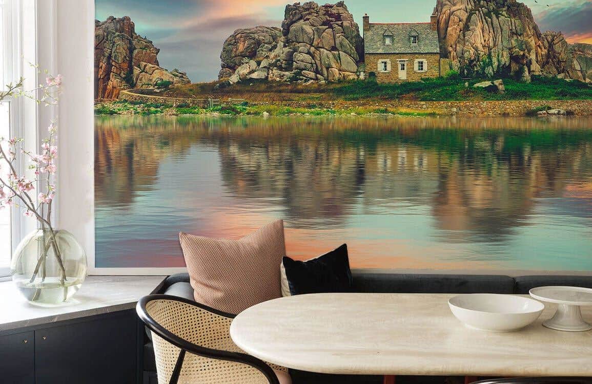 wallpaper mural showing an image of a cottage surrounded by rocks by a lake.