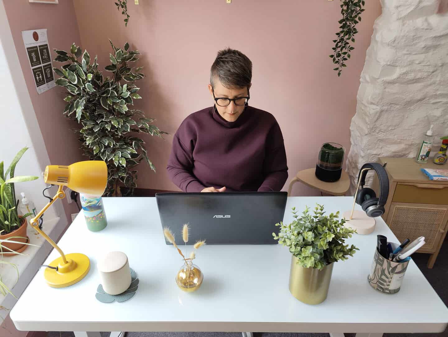 A white woman in her 40's works at the Flexispot EG8 Comhar Sit Stand Desk in seated position.