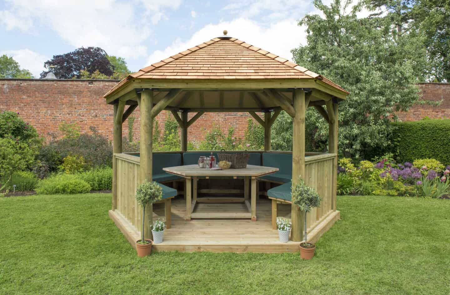 a garden featuring a 4m Premium Hexagonal Wooden Garden Gazebo with Cedar Roof