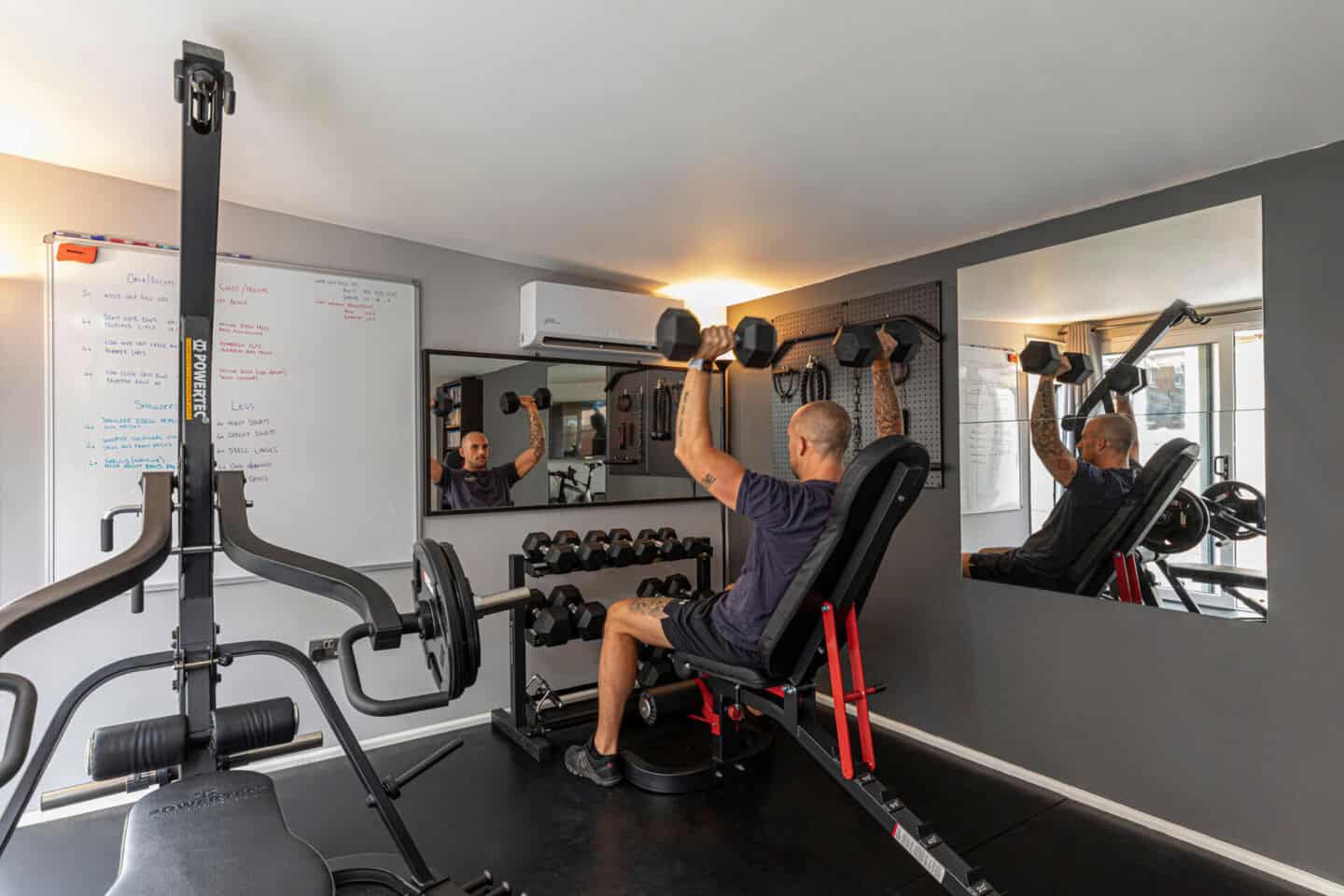 A man in a home gym lifting weights