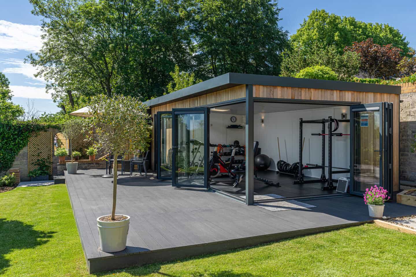 Home gym in a garden room full of workout equipment and machinery 