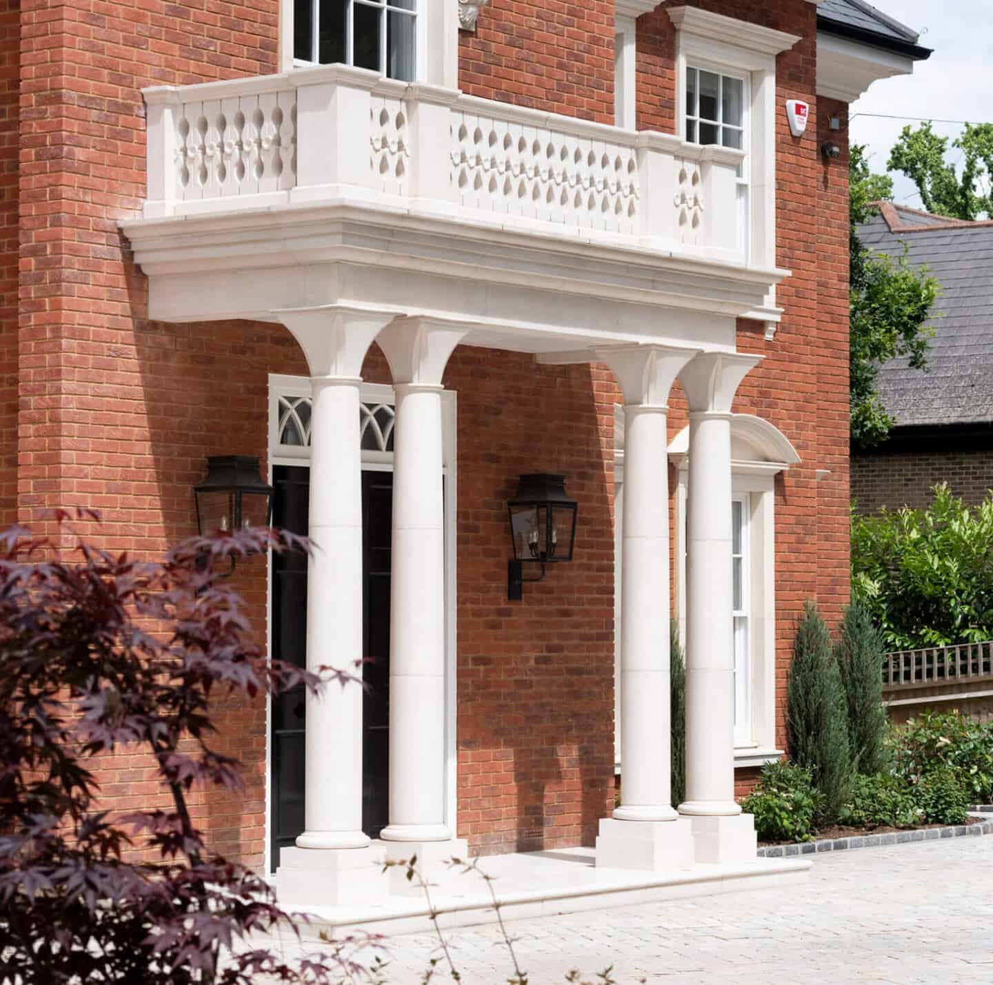 A red brick home with a white portico gives string curb appeal