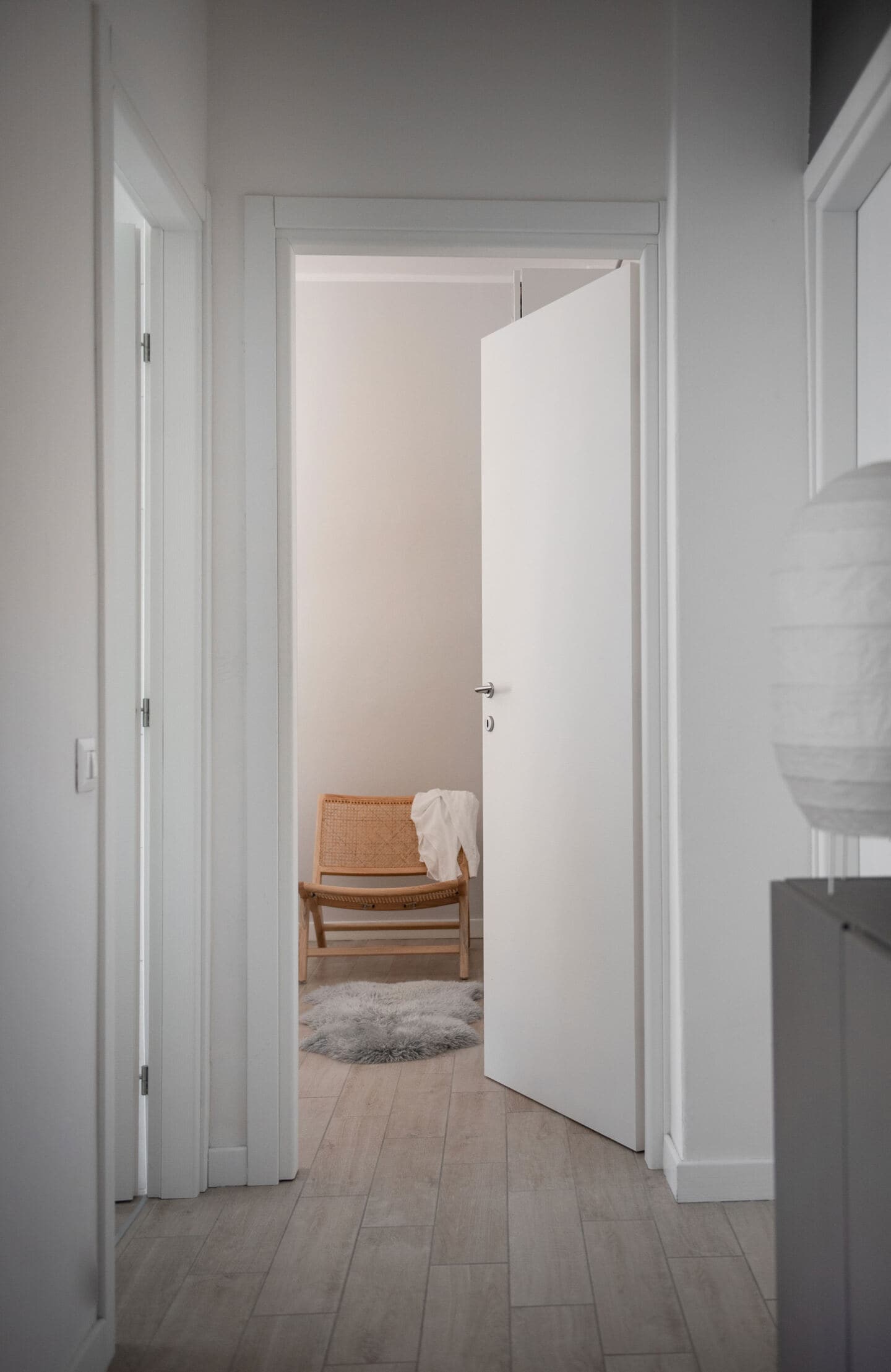 View from the hallway into a bedroom through a partially closed door