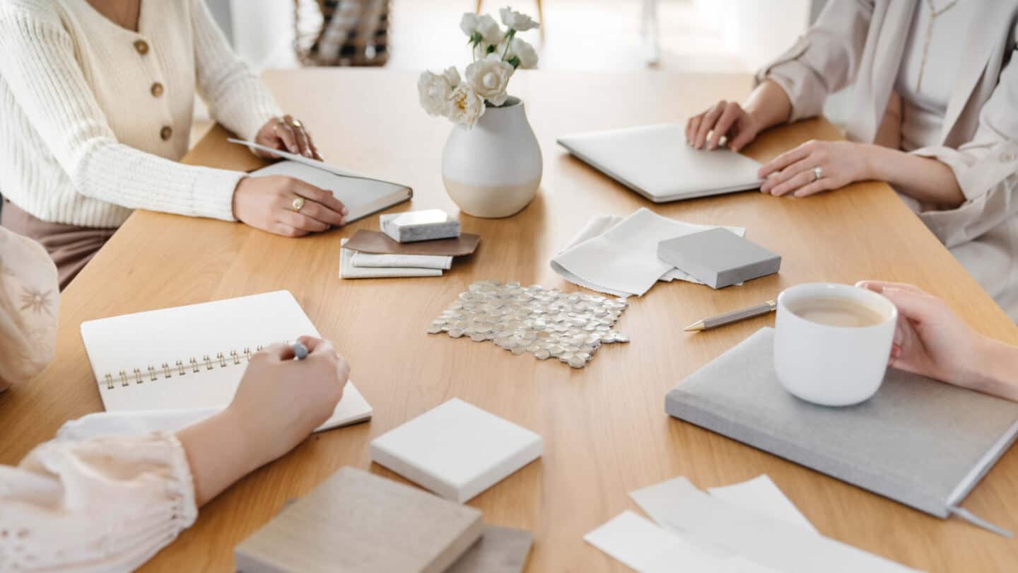 4 women sit around a table planning an interior design project