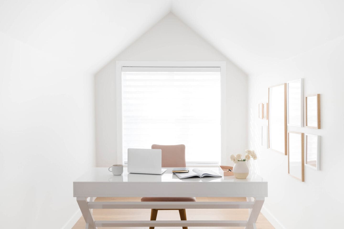 A minimal and productive home office with sloped ceiling and large window