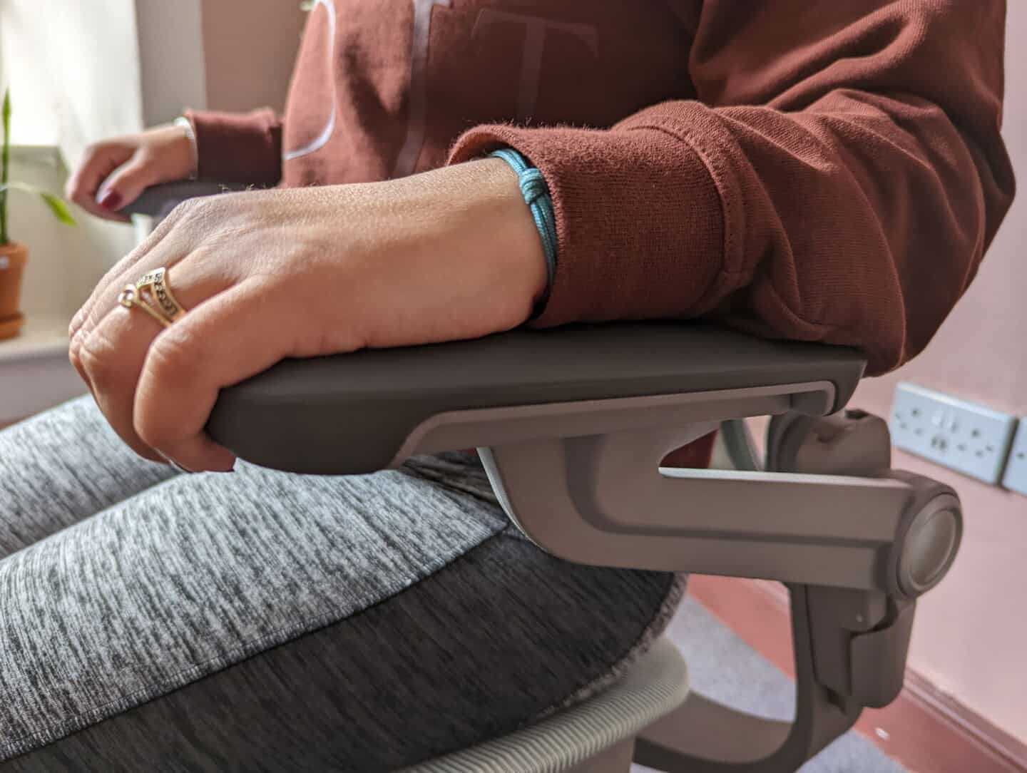  A close up of a woman's arm on the armrest of an Ergonomic Office Chair